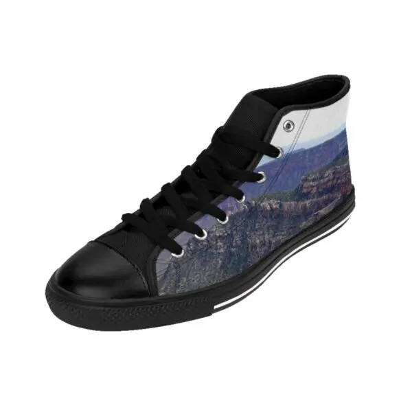 A pair of black shoes with mountains in the background.
